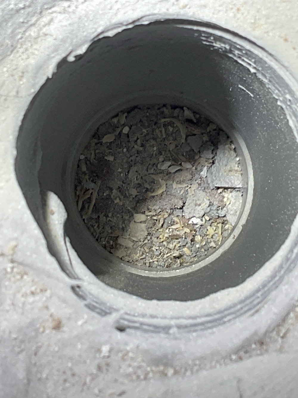 Shower drain full of cement debris, recorded during a fixing inspection in Fraser Rise, 4 km from Rockbank